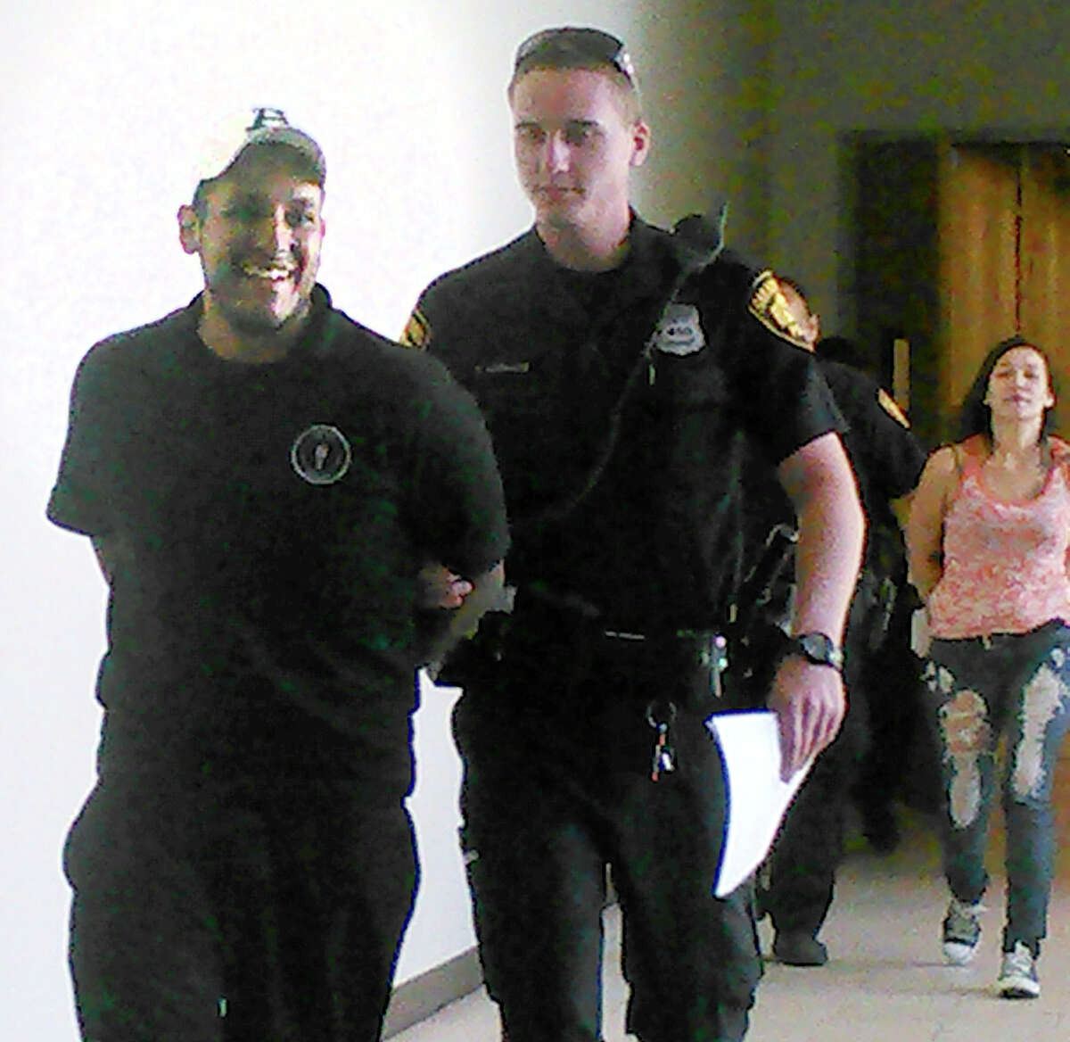 Joe Martinez, 24, left, was arrested April 4 on a warrant for the 2010 killing of David Valdez. His then-girlfriend, in background, Rebecca Rodriguez, 23, was also arrested on a charge of felony theft.
