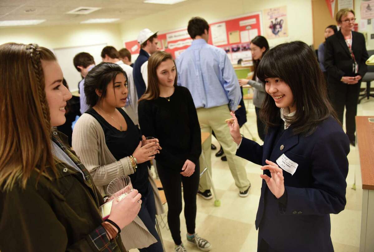Greenwich students, from left, freshman Ava Zabik, freshman Hannah Crasto and sophomore Julia Conti talk with Japanese business student Mizuho Utsugi at Greenwich High School in Greenwich, Conn. Wednesday, March 18, 2015. Greenwich High School welcomed a visiting group of Japanese high school juniors who won a mock stock investing league in Japan. The visitors met with Greenwich High business education students and teachers to talk about investments and compare American and Japanese approaches to business education.
