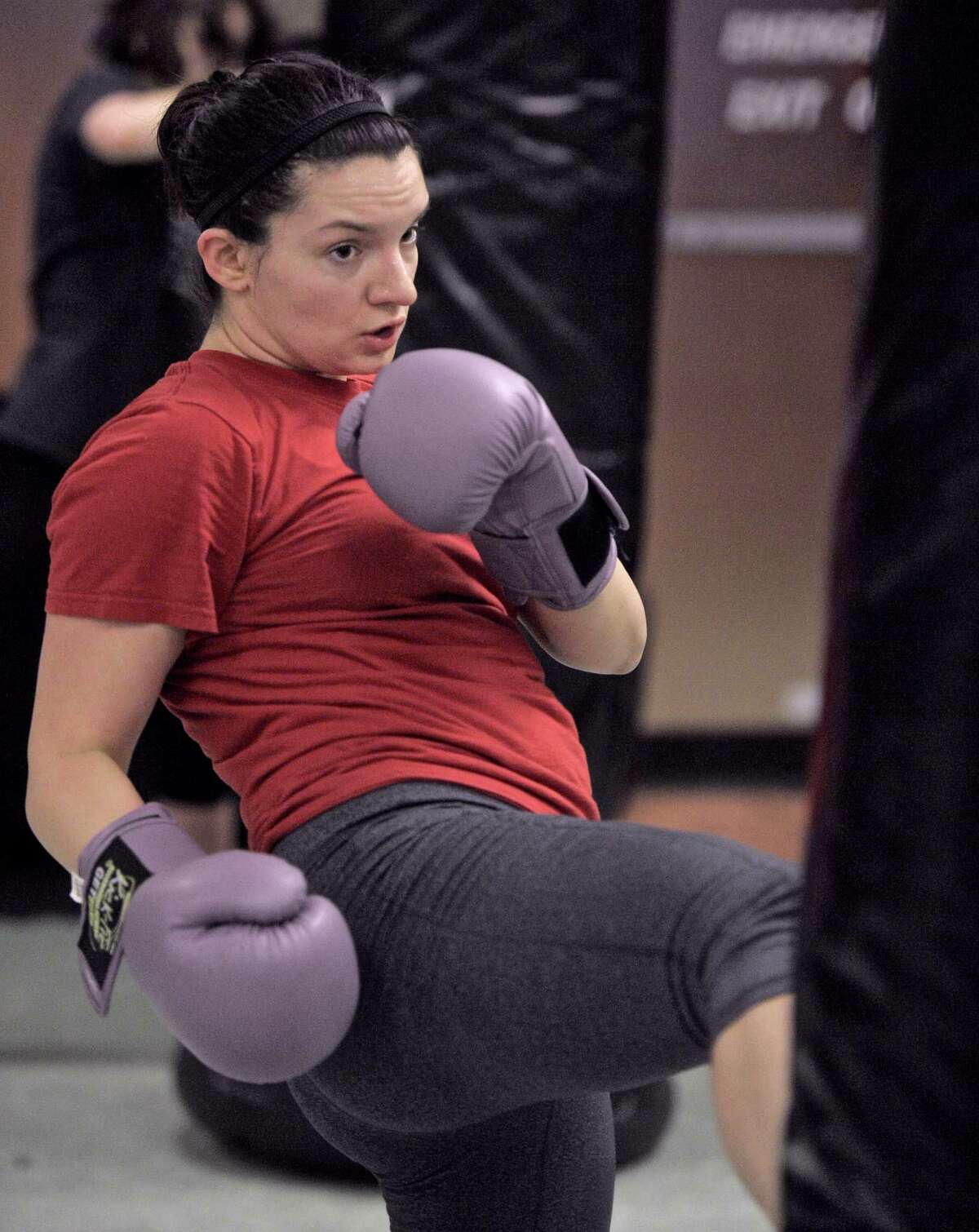 Lauren Brown, of Danbury, kicks a heavy bag during a KickFit class at Connecticut Martial Arts - Danbury Martial Arts Training Center on Wednesday, March 18, 2015, in Danbury, Conn.