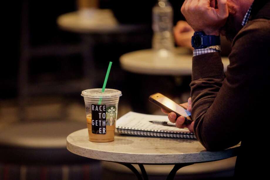A cup with one of Starbucks' "Race Together" stickers, seen at a store in New York, is part of a campaign intended to stimulate dialogue on race. Many observed that for however well-meaning the act, it was "the height of liberal American idealism and a staggering act of hubris to think we can solve out systemic addiction to racism over a Frappucino," leaving Starbucks' oft-put-upon baristas to sop up potential mess. Photo: SAM HODGSON, STR / NYTNS