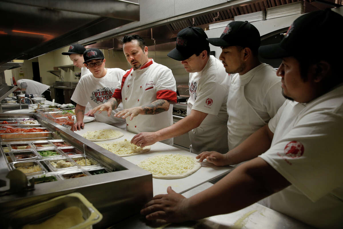 At Pizza Rock near Las Vegas, Tony Gemignani (center) demonstrates the proper technique to his kitchen staff.