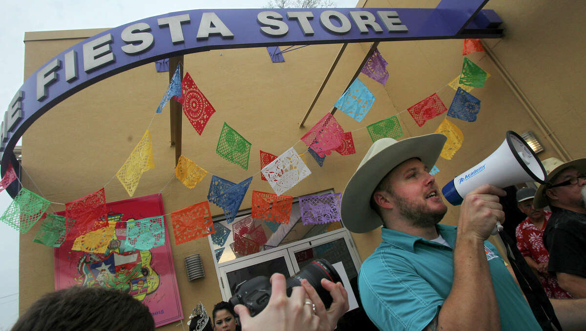 Nick Kaylor (right) makes an announcement to people in line Friday March 20, 2015 at the Fiesta Store at 2611 Broadway. There were two lines at the event. One was for the purchase of Fiesta event tickets such as parades and the other line was for the purchase of a new Coyote Fiesta medal. Customers are being limited to buying a maximum of five Coyote medals. Fiesta runs from April 16-26, 2015.
