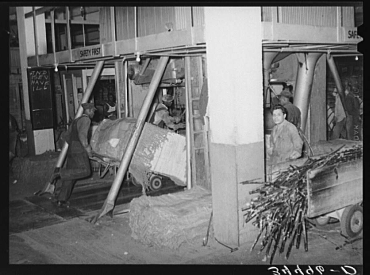 October 1939 : Placing a bale of cotton into compressing unit in Houston.