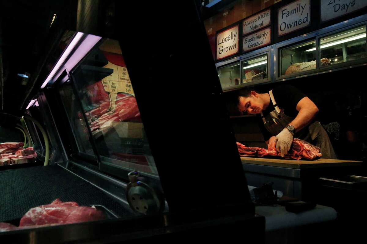 Butcher Kyle Morgan prepares dry-aged rib eye, above, and ham burger patties, left, at the Five Dot Ranch storefront and restau r ant in the Oxbow Market in Napa. The ranch produces beef raised on grass and California grains.