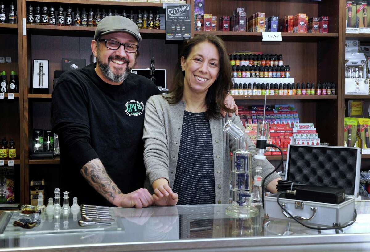 Matt and Jen Osmun, owners of Grassy Plain Vape and Smoke pose in their Bethel, Conn. location on Friday, March 20, 2015.