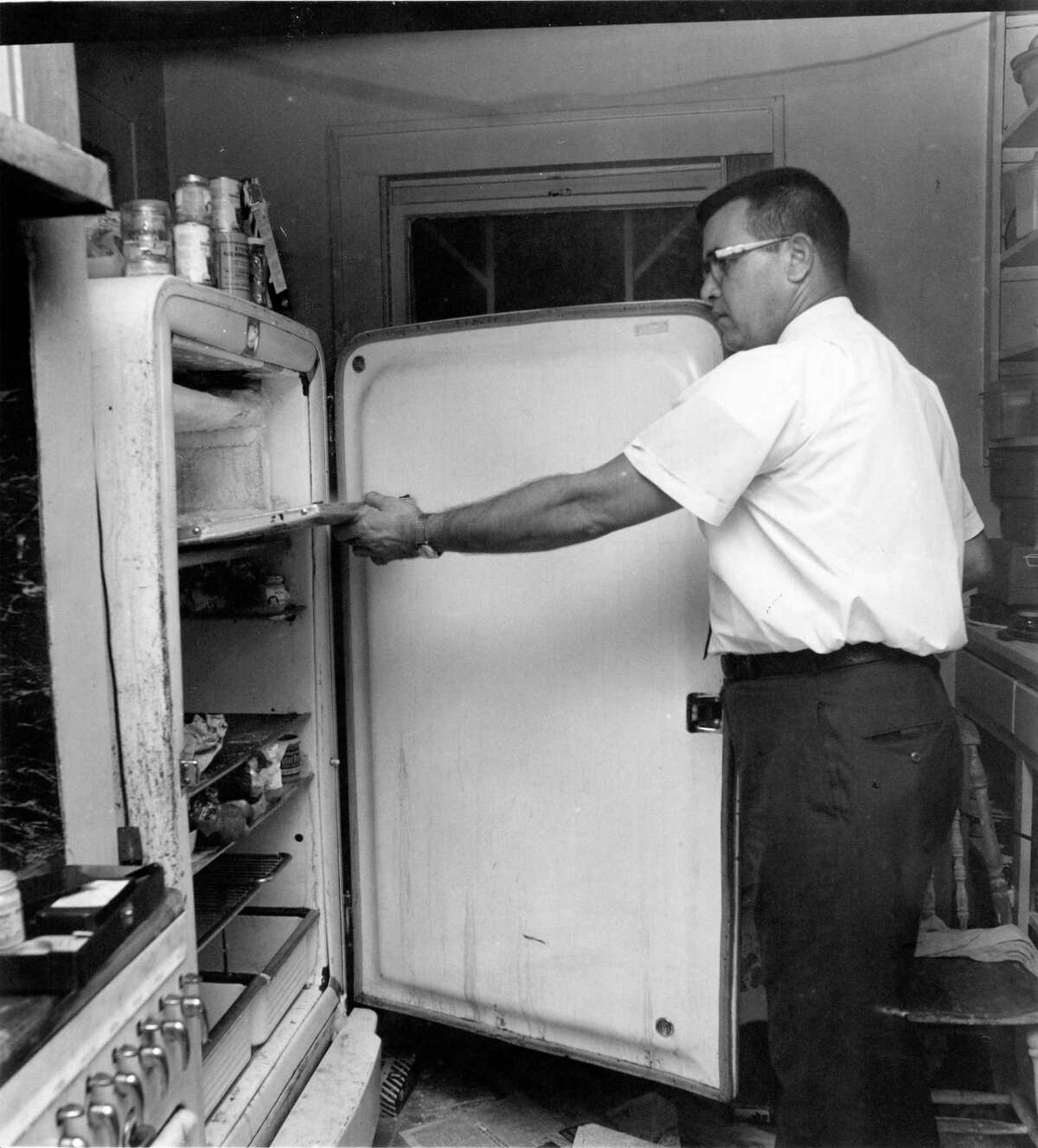 Houston Police homicide detective J.P. Paulk examines the freezer compartment of a refrigerator where a torso was found. Fred C. Rogers, 81, and his wife, Edwina Harmon Rogers, 79, were found dismembered in their refrigerator at 1815 Driscoll on June 23, 1965.