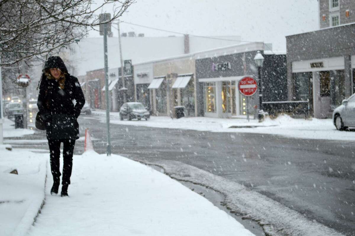 Jackie Toth was one of the few pedestrians on Main Street Friday afternoon as several inches of snow fell on the first day of spring.