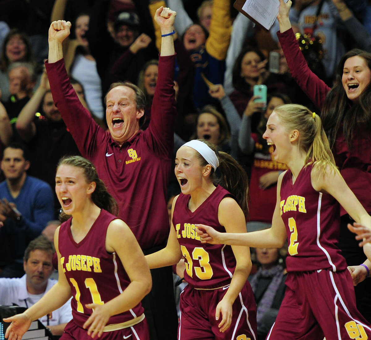 St. Joseph's coach Chris Lindwall and his team react as they beat Cromwell, during CIAC State Girls Basketball Tournament action at Mohegan Sun in Uncasville, Conn., on Saturday Mar. 21, 2015.