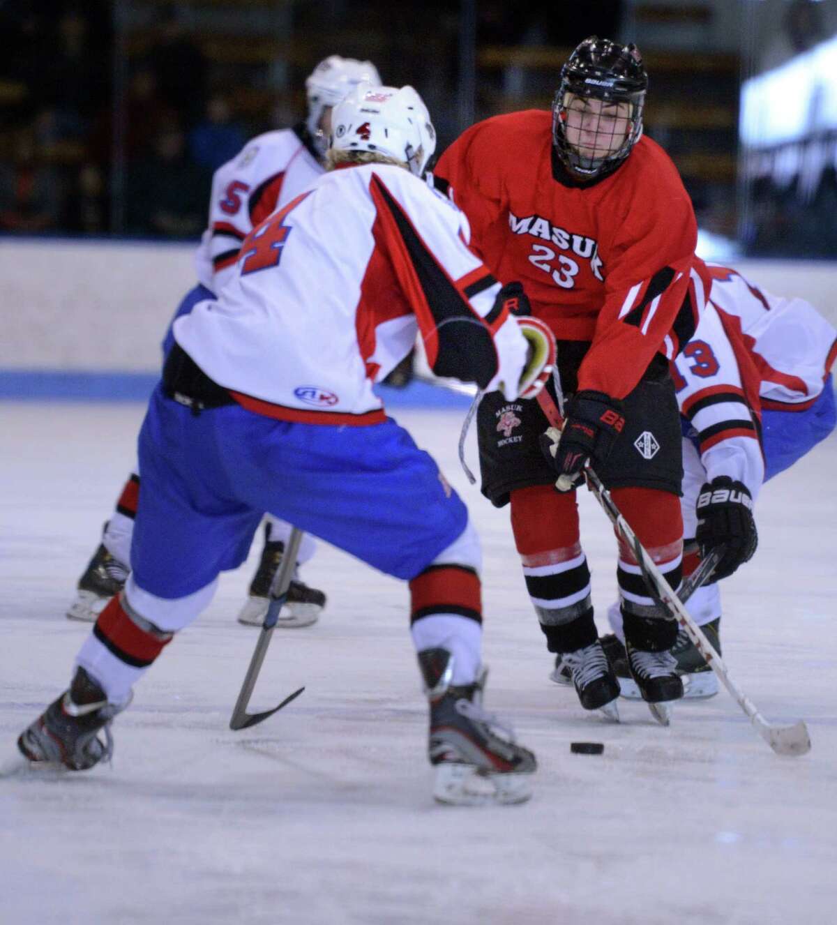 Masuk's Brian Denham moves the puck between E.O. Smith-Tolland defenders Cameron Burns, left, and Dylan Coughlin Saturday, Mar. 21, 2015 during the division III state hockey championship at Ingalls Rink in New Haven, Conn.
