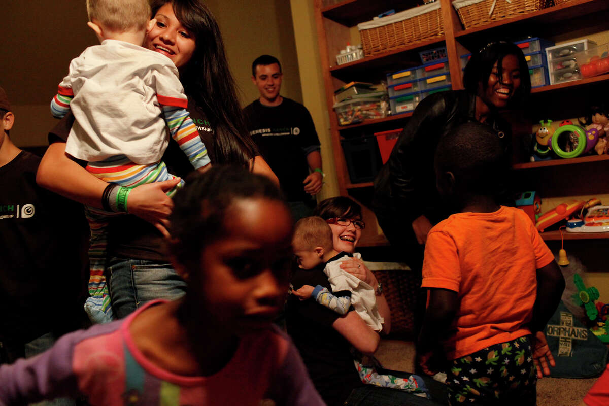 The Patterson family wakes up to greet their new siblings, Cooper and Conner, as they arrive at their new home in Wimberley after midnight after flying into Austin from Ukraine. From left, Meribeth, adopted from Colombia, holds Cooper while Ella, adopted from Texas, runs by and biological child Parker enters the room as biological child Mattie, holds Conner, with Naomi, right, and Kiefer, both adopted from Haiti joining the excitement.