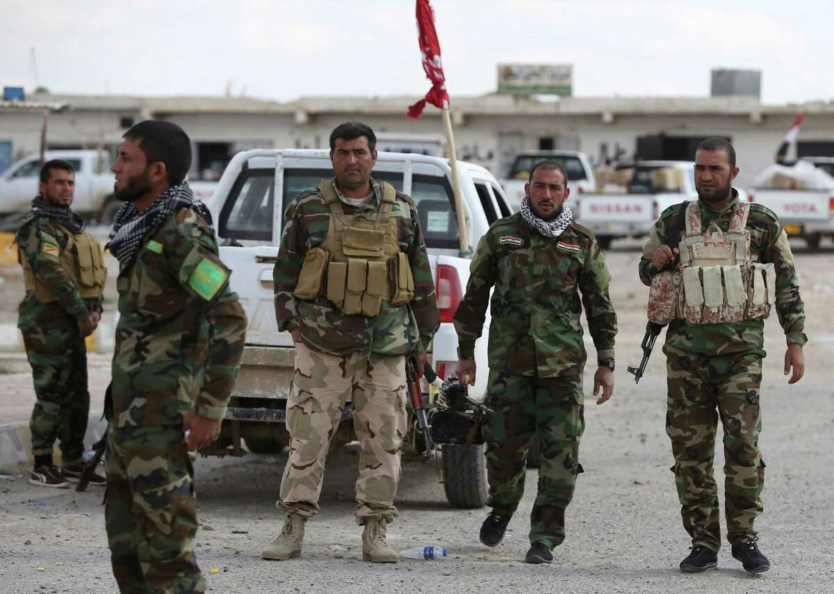 Iraqi Sunni fighters stand at a checkpoint at the entrance of Al-Alam.