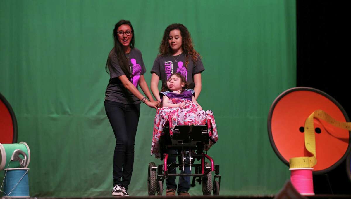 Designers O'Connor high school senior Claudia Arredondo, 17, (from left) and junior Anna Nelms, 17, take the runway with model Rahe Bulverde elementary 2nd grader Bella Dillingham, 8, during the 8th annual FashionAble show held Sunday March 22, 2015 at O'Connor High School.