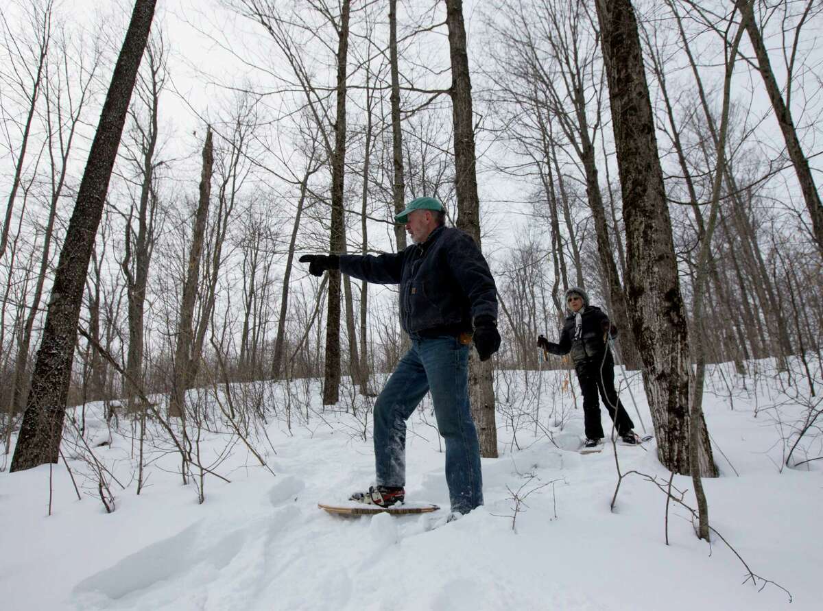 In this Thursday, Feb. 26 photo, Dev Kernan and his wife Karen Butler snowshoe on family property along the proposed path of the Constitution Pipeline in Harpersfield, N.Y. The 124-mile Constitution Pipeline will likely bring some relief from relatively high natural gas prices to residents of New York City and New England, but it will also bring anguish to many landowners in the wooded hills and valleys in its path. It will slash a mile-long gash through a pristine forest tended by the Kernan family for seven decades. (AP Photo/Mike Groll) ORG XMIT: NYMG201