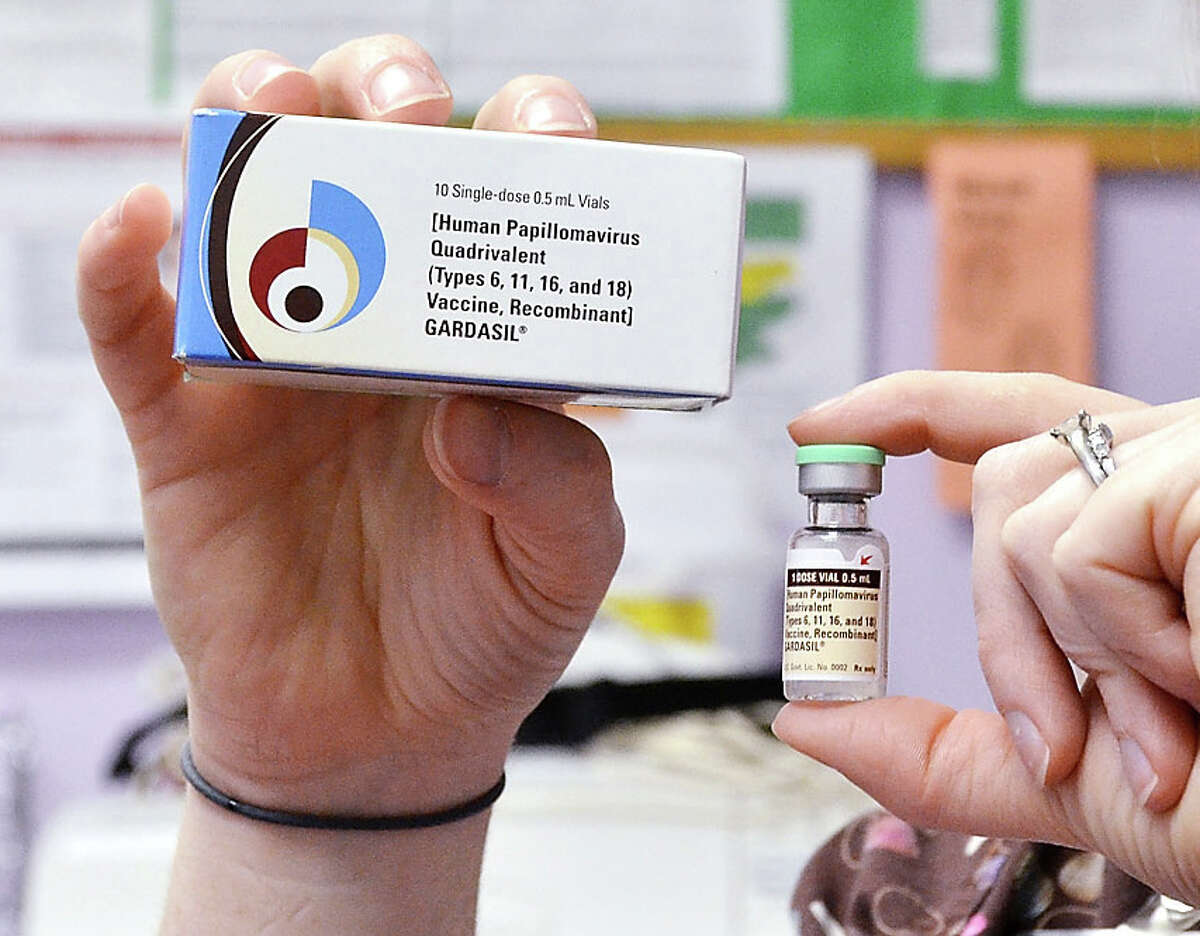 A child health nurse holds up a vial and box for the HPV vaccine, brand name Gardasil, at a clinic in Kinston, N.C. on Monday March 5, 2012. A vaccine against a cervical cancer virus has cut infections in teen girls by half, according to a study released Wednesday, June 19, 2013. The study confirms research done before the HPV vaccine came on the market in 2006. But this is the first evidence of how well it works now that it is in general use. (AP Photo/Daily Free Press, Charles Buchanan)