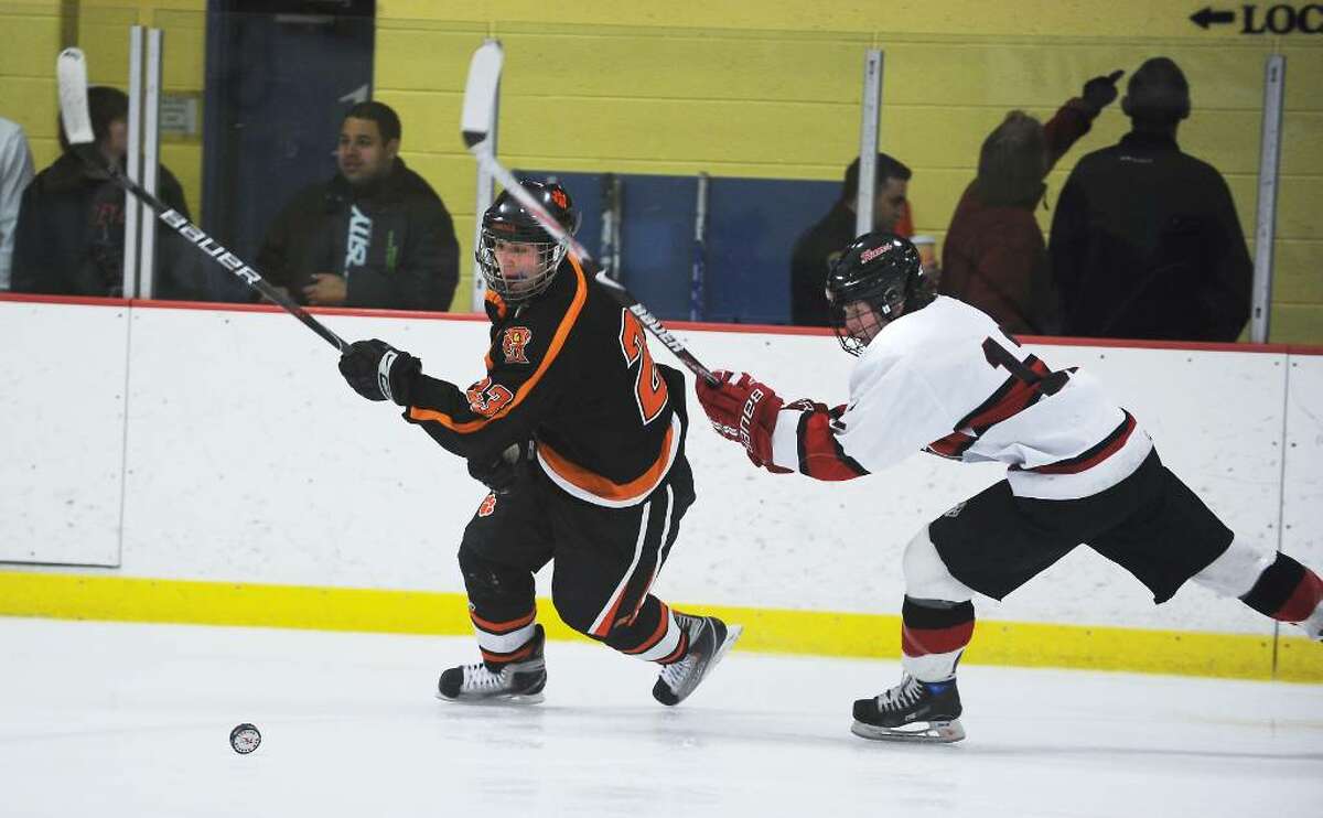 Ridgefield's Duncan Morrissey and New Canaan's Tim Robustelli battle for control of the puck in the FCIAC boys hockey championship game at Terry Conners Rink in Stamford, Conn. on Saturday, March 6, 2010.