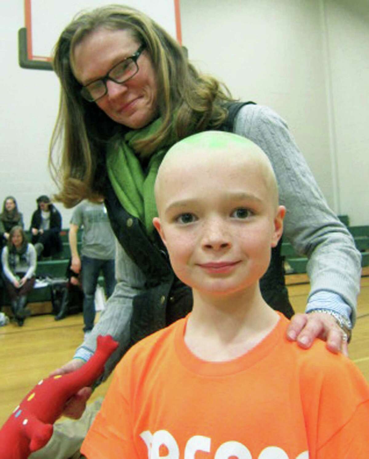 NMHS teacher Darcy Campbell and her newly shorn, 9-year-old son, Spencer, soak in the atmosphere during New Milford's High School's St. Baldrick's Foundation head-shaving fundraiser. Spencer proved a passionate fundraiser, soliciting $2,462 in donations. March 16, 2015