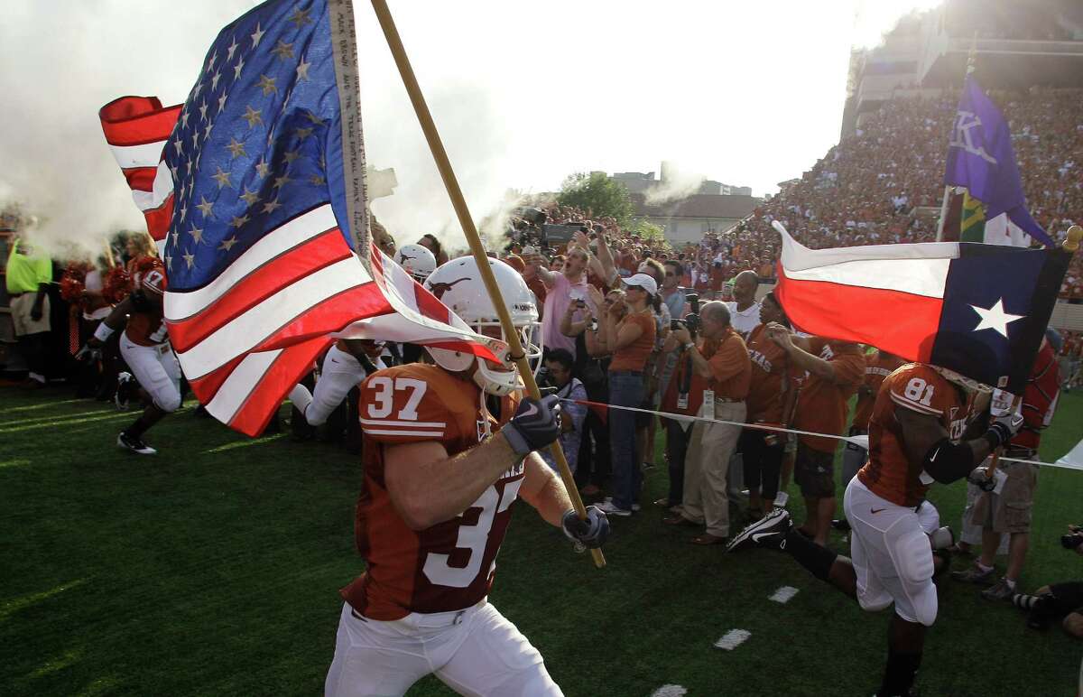 Texas' Nate Boyer (37) runs onto the field with the U.S. Flag as teammate Sam Acho (81) carries the Texas flag when they take the field to play Wyoming in an NCAA college football game, Saturday, Sept. 11, 2010 in Austin, Texas. (AP Photo/Eric Gay)