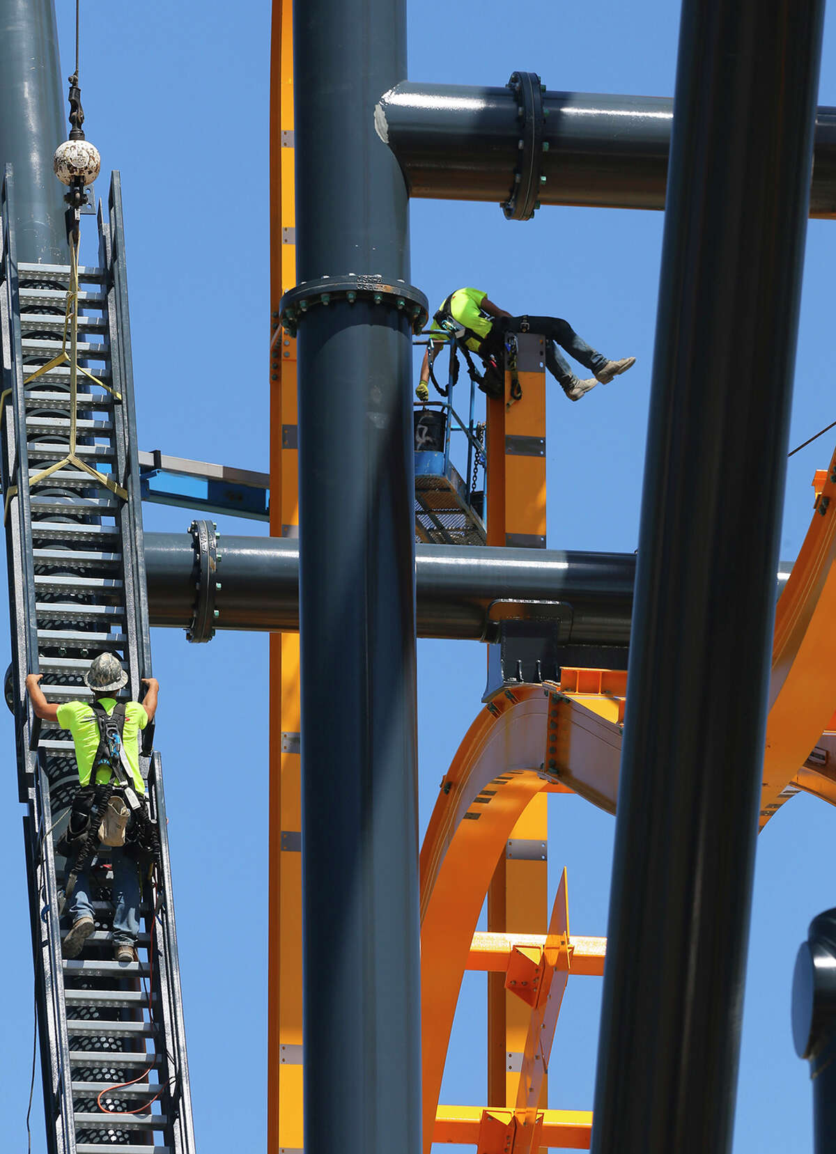 A piece of stairwell (left) is hoisted into place Wednesday March 25, 2015 on a new roller coaster ride at Six Flags Fiesta Texas. The roller coaster, called BATMAN: The Ride, is known as a 4D Wing coaster and lifts riders up 120 feet. Riders are flipped head-over-heels and will experience tumbling and unexpected drops along the way. The attraction is based on the Batman comic and offers immersion into the Batman storyline. The ride uses magnetic technology and has two beyond 90 degree drops giving the sensation of free-falling. The attraction has five vehicles with eight passengers each and will open in early summer 2015.