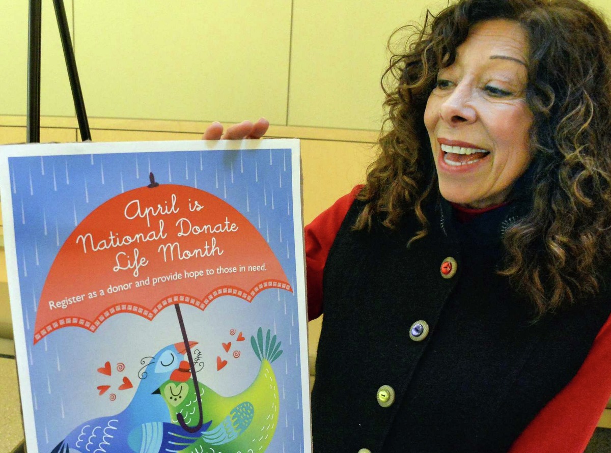 Kidney transplant recipient Grace Anderson of Chatham with an organ donator poster during the announcement of successful outcomes data for the kidney transplant program at Albany Medical Center Tuesday March 25, 2015 in Albany, NY. (John Carl D'Annibale / Times Union)