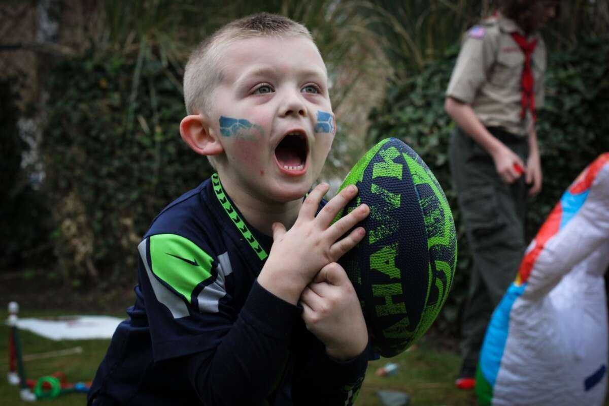 Eben Bland Jr., 5, barely catches a football during the inaugural 12s Rally for 12s, a Seahawks rally and fundraiser at the Ballard Elks on Sunday March 29, 2015. Fans gathered to raise money for local charities and help 12 fan John Bachner, who was paralyzed last September in a car accident. (Daniella Beccaria, seattlepi.com)