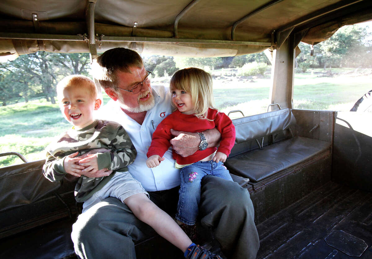 Kaj Ahlmann, the owner of Six Sigma Ranch & Winery, takes a ride in his 1973 Pinzgauer to the top vineyard with two of his grandkids, Caleb, 4, left, and Elizabeth, 2, right, in Lower Lake.