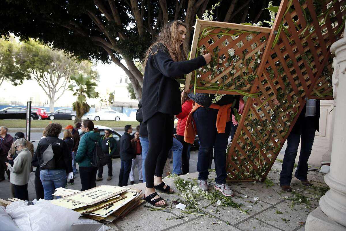 Caitlyn Cournale, 17, who has a sister who attends Sacred Heart Acadmey, helps prepare a flowered cross before joining other opponents of Archbishop Cordileone's new rules for teachers at Catholic high schools in a Holy Week procession from Mission Delores Church to St. Mary's Cathedral in San Francisco, Calif., on Monday, March 30, 2015.