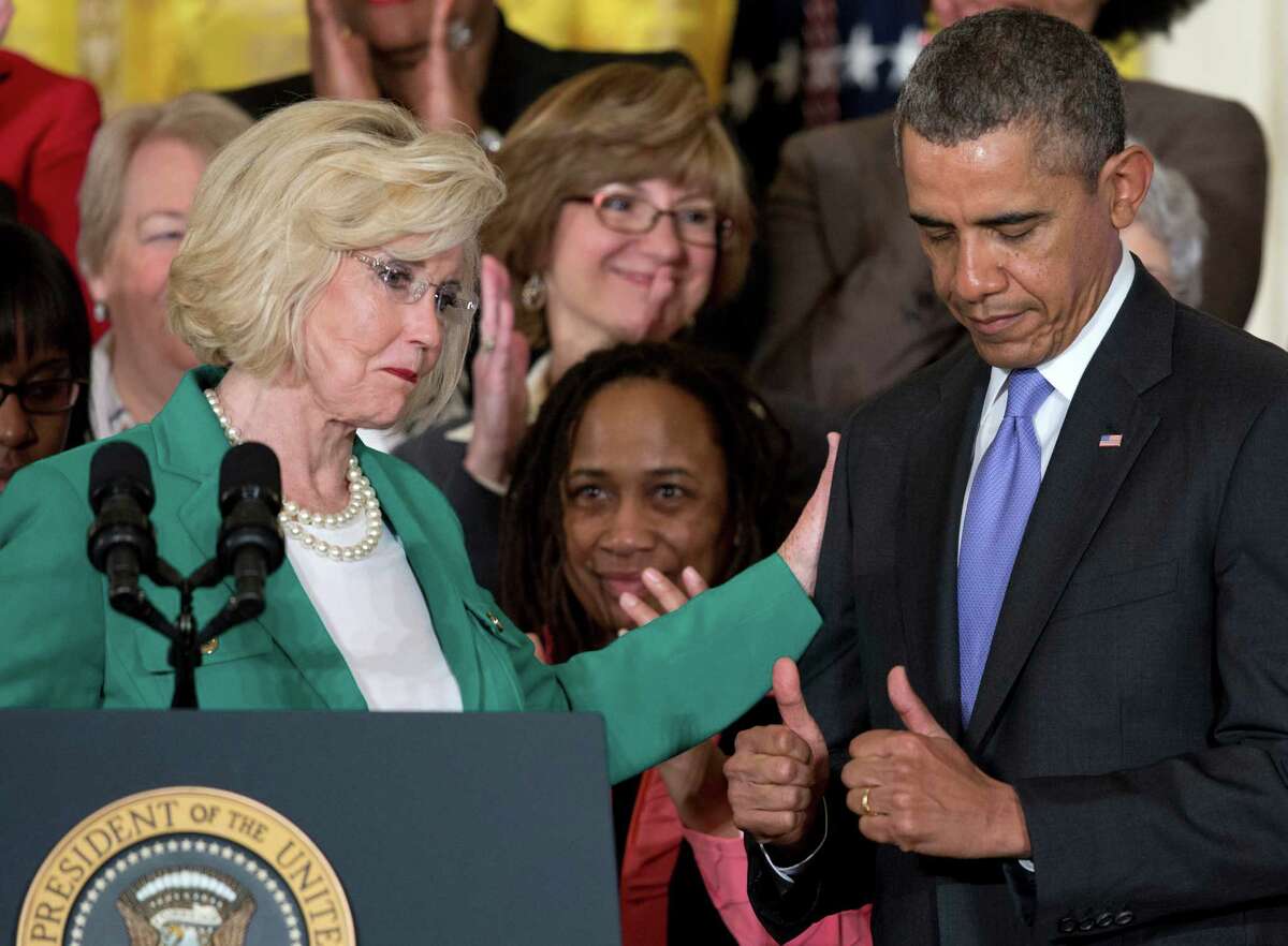 President Obama gives two thumbs as women’s rights activist Lilly Ledbetter acknowledges him in a 2014 White House ceremony marking Equal Pay Day.