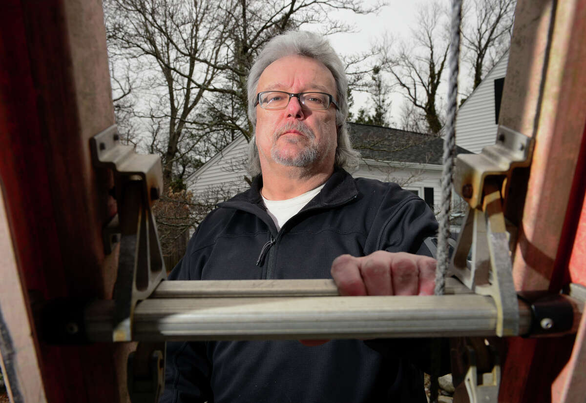 Stan Bajerski, of Houseworks Home Inspections, poses with one of his ladders that he uses on the job in Milford, Conn., on Tuesday Mar. 31, 2015. Bajerski is also president of the Connecticut Association of Home Inspectors.