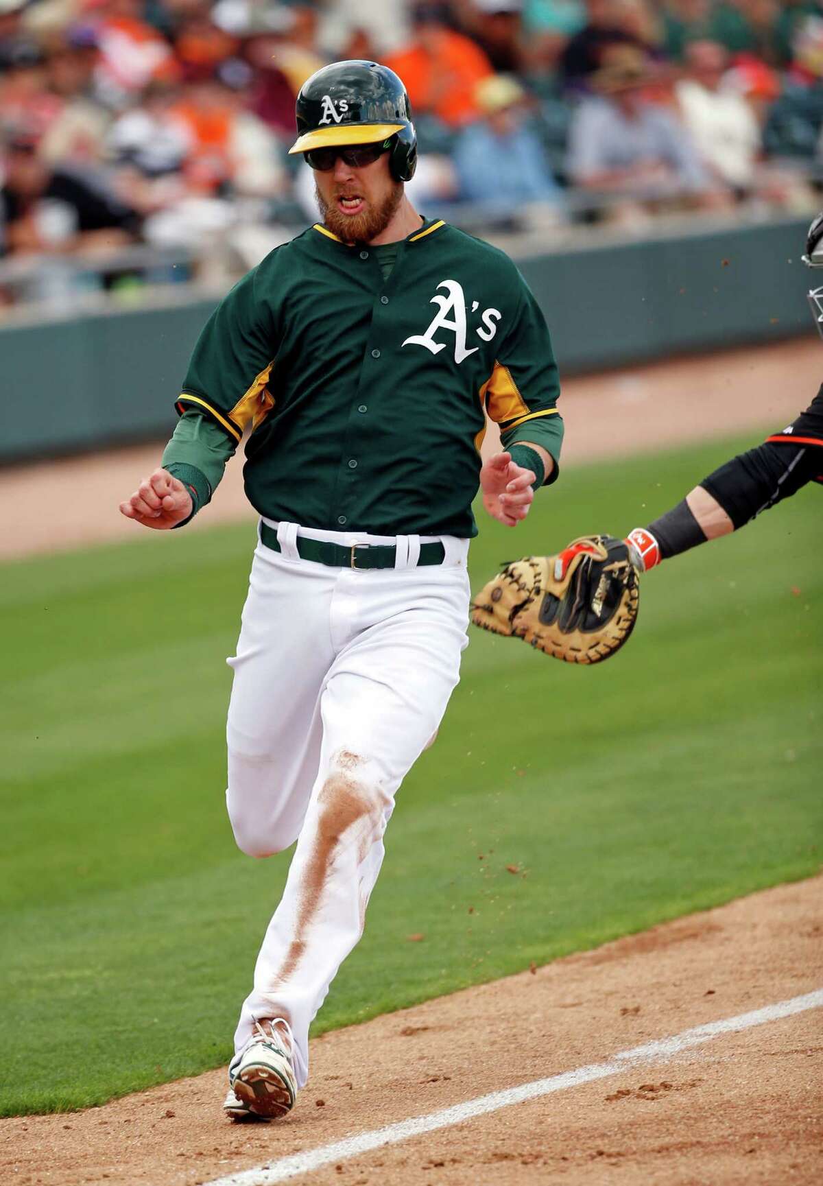 Left, A’s super utility man Ben Zobrist scores on Billy Butler’s sacrifice fly in their Cactus League opener against the Giants last month. The A’s top three projected power hitters combined for 32 home runs last season.