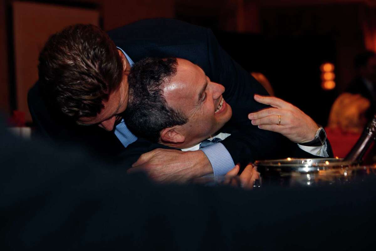 After being named the San Francisco Chronicle's Visionary of the Year recipient at the Fairmont Hotel, Evan Marwell (center), CEO and founder of EducationSuperHighway is hugged by Matt Roberts, CEO of OpenTable, Tuesday, March 31, 2015, in San Francisco, Calif.