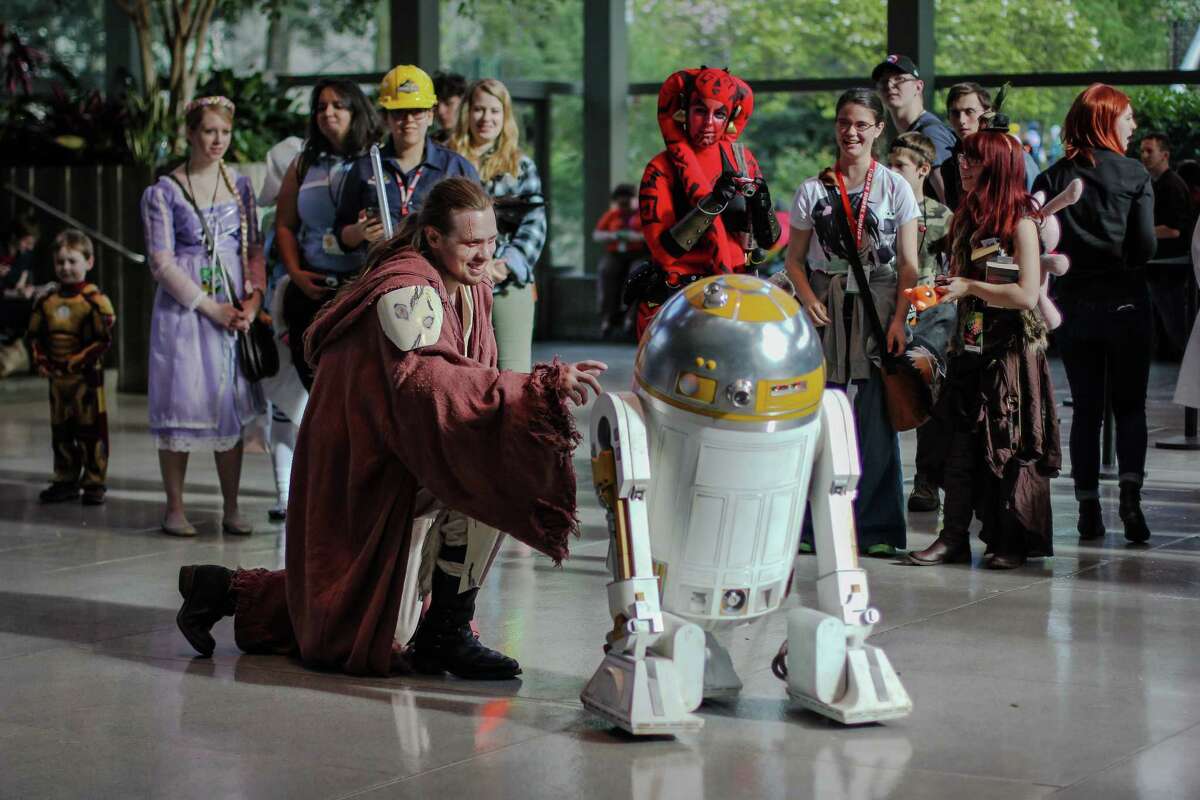 A Jedi interacts with a droid during day two of Emerald City Comicon at the Washington State Convention Center on Saturday, March 28, 2015. The three day convention is the largest comic book and pop culture convention in the Pacific Northwest. The convention features cosplay, comic books, celebrities and more.