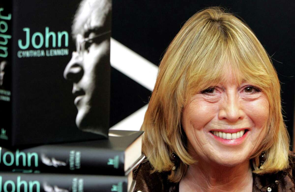 File- In this Sept 26, 2005 file photo, Cynthia Lennon, the first wife of Beatle's band member John Lennon, sits behind copies of her newly released book entitled 'John' during a book signing at Foyle's bookshop in central London. Cynthia Lennon passed away on Wednesday, April 1, 2015 at her home in Mallorca, Spain, following a short but brave battle with cancer. (AP Photo/ Jane Mingay, File)