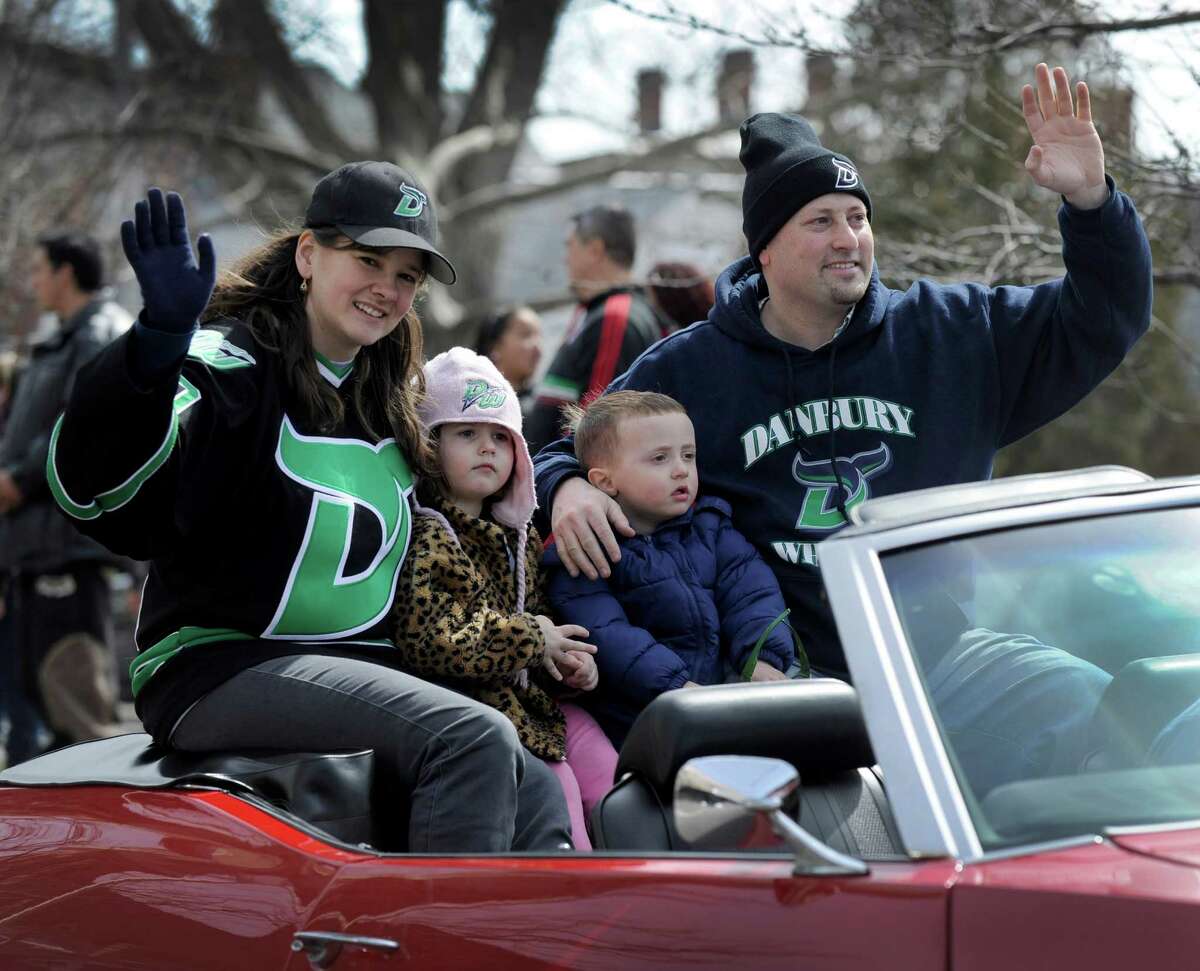 Herm Sorcher, CEO and managing partner of the Danbury Whalers, right, rides in a victory parade Sunday, March 24, 2013, down Main Street in Danbury, Conn. With him from left are, Tricia Coe, director of fund raising for the team and Sorcher's children, Samantha, 4, and Max, 3.
