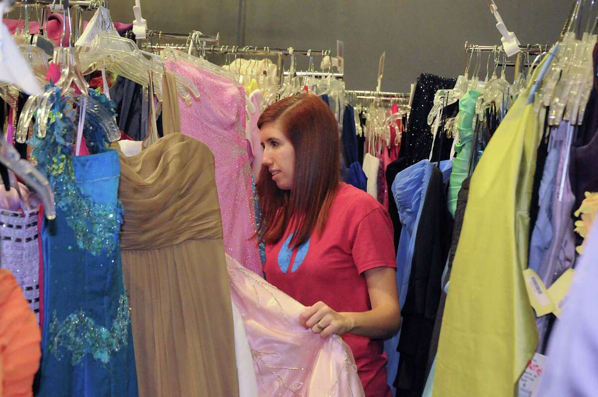 Giving Gowns Foundation co-director Leigh Ann Sharp arranges some of the 1,100 donated prom dresses that will be given to junior and senior high girls.