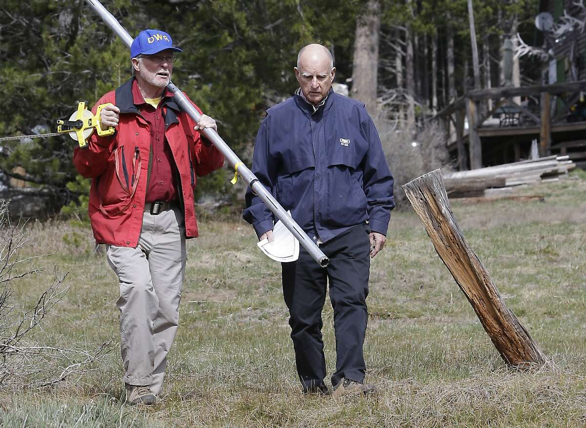 Frank Gehrke, left, chief of the California Cooperative Snow Surveys Program for the Department of Water Resources, and Gov. Jerry Brown walk across a dry meadow that is usually covered in several inches of snow as conducts the snow survey, near Echo Summit, Calif., Wednesday, April 1, 2015. Gehrke said this was the first time since he has been conducting the survey that he found no snow at this location at this time of the year. Brown took the occasion to annouced that he signed an executive order requiring the state water board to implement measures in cities and towns to cut water usage by 25 percent compared with 2013 levels. (AP Photo/Rich Pedroncelli)