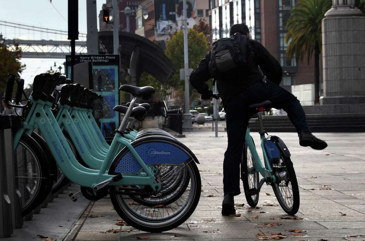 A commuter uses the Bay Area Bike Share station at Harry Bridges Plaza in San Francisco to get to work on Nov. 12, 2013.