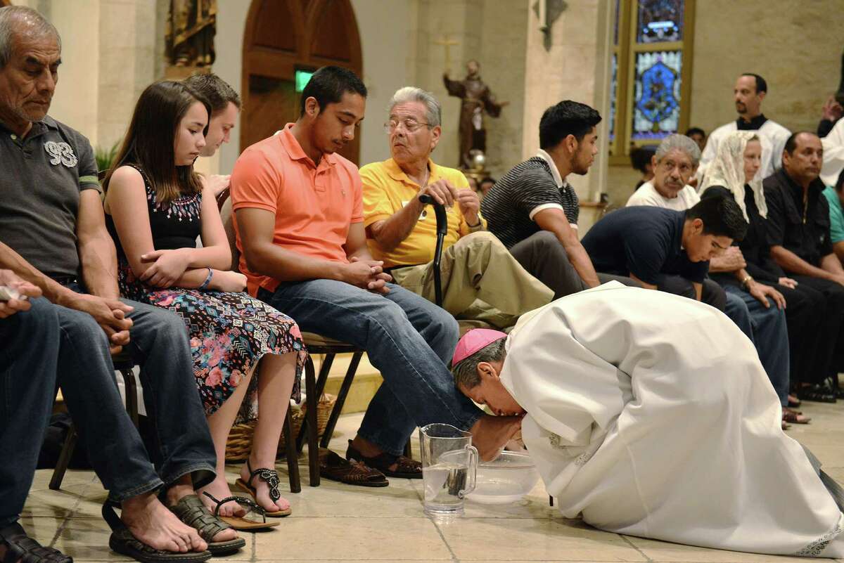 Archbishop Gustavo Garcia-Siller kisses and washes the feet of Emmanuel Quijano and other members of the congregation at San Fernando Cathedral on Holy Thursday, April 2, 2015 in San Antonio. Emmanuel Quijano, will be playing Jesus in the passion play tomorrow.