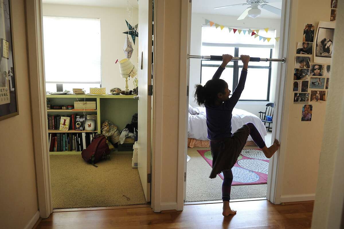 Carter., 6, hangs on a pull-up bar in the doorway of her room in her apartment in the Uptown area of Oakland, CA, on Monday, April 2, 2015.