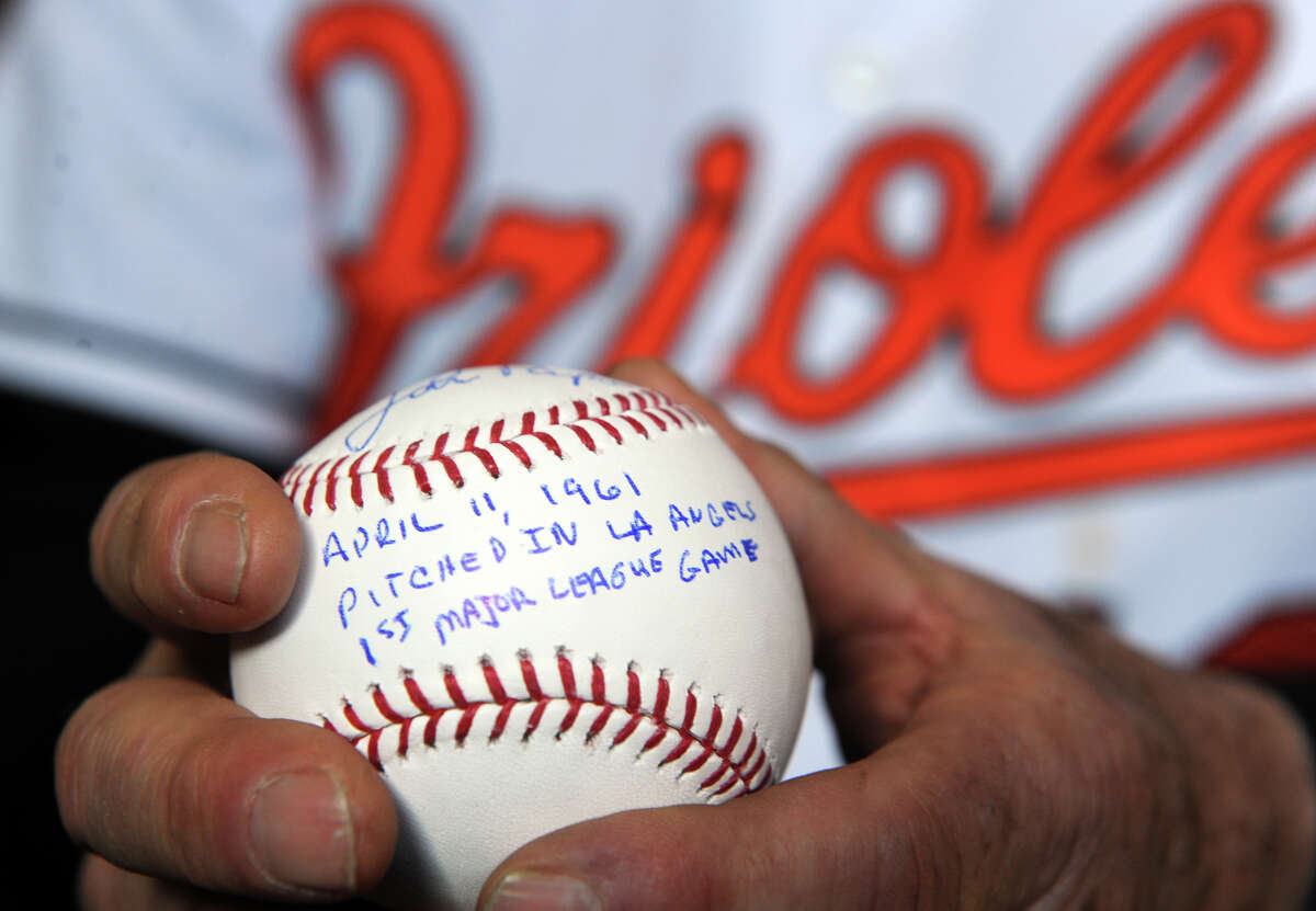 John Papa, a former Major League Baseball player with the Baltimore Orioles, holds a ball bearing his signature Wednesday, Mar. 25, 2015, at his home in Shelton, Conn.