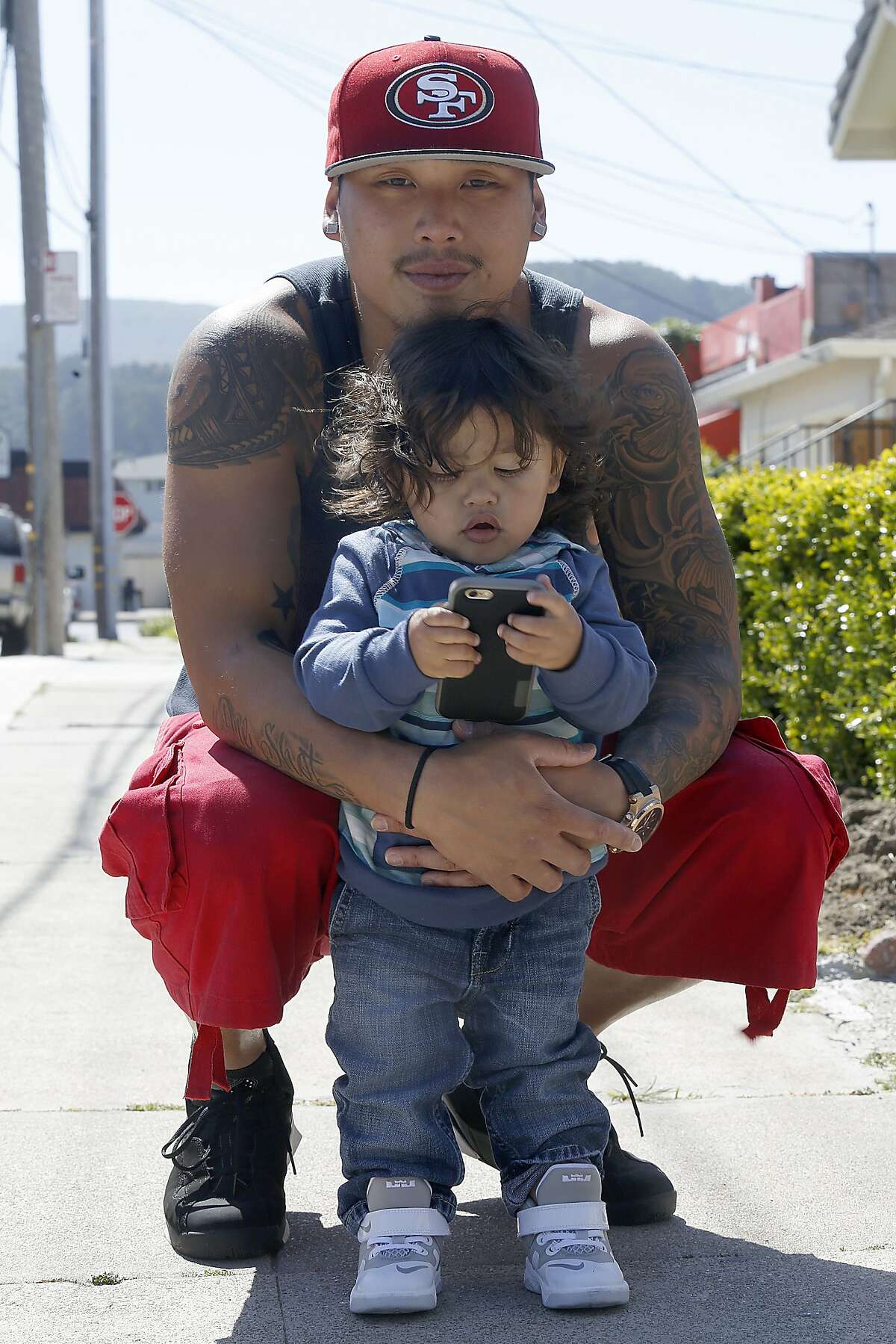 Kevin Yip playing with his 22 month old son, Dominic King Yip in front of his parents' home where he grew up in San Bruno, California, on Friday, April 3, 2015.