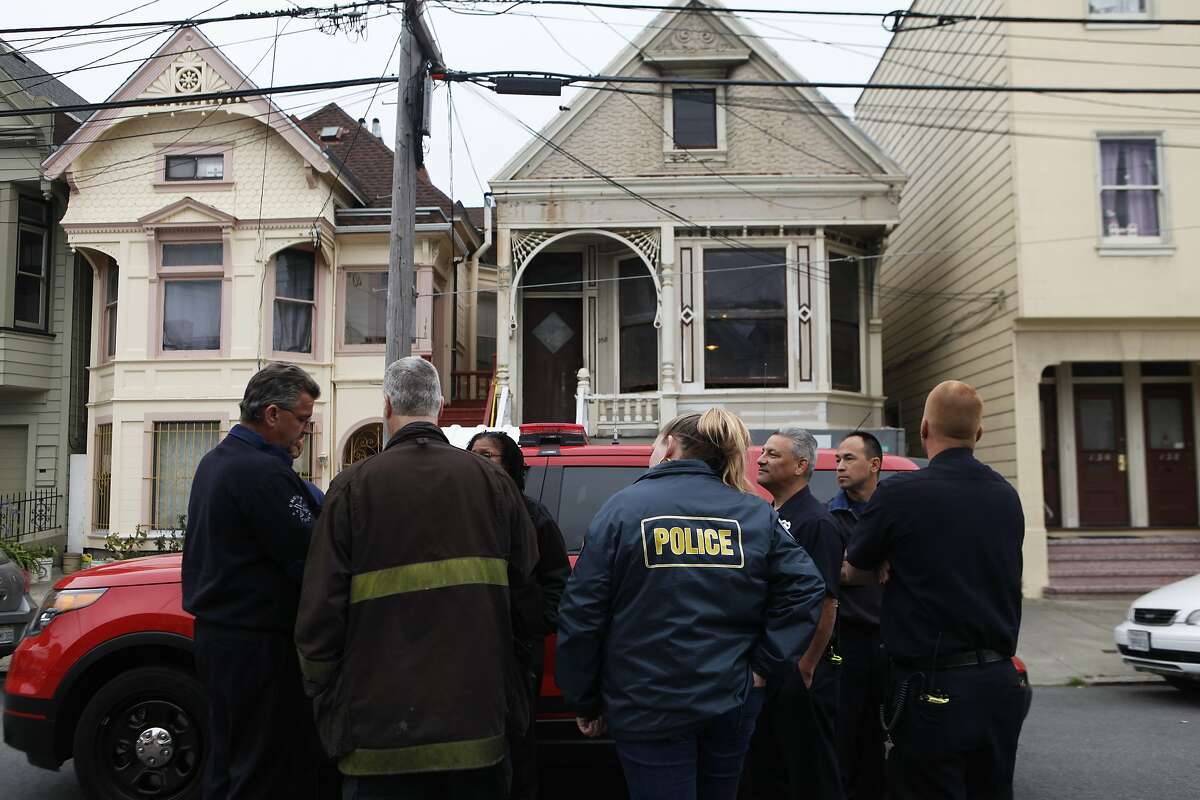 Emergency crews collaborate outside a home near 4th and Lake Street in the Richmond District of San Francisco, Calif. after a body was reported inside the house Saturday, April 4, 2015.
