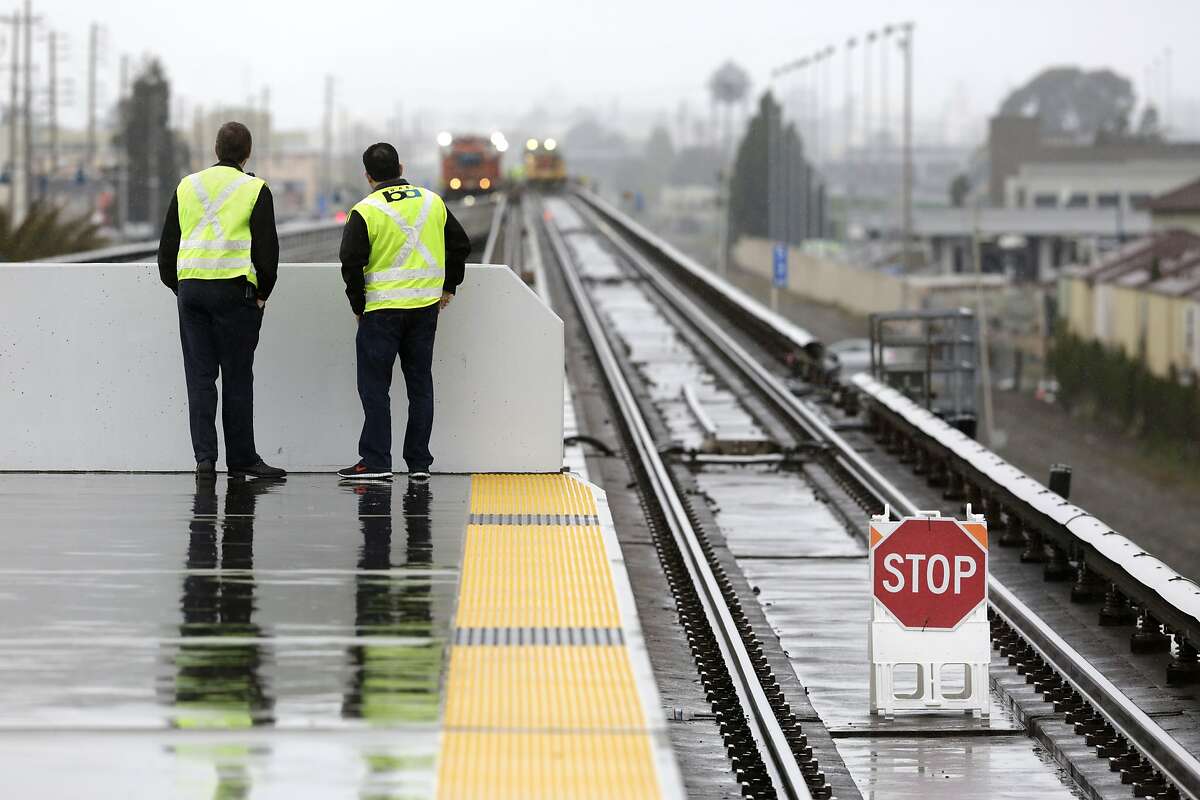 BART Manager of Rail Operations Colby Barry (left) and Chief Transportation Officer Roy Aguilera watch maintenance work underway beyond the north end of the Coliseum Station platform in Oakland on Sunday, April 5, 2015. A section of track between the Coliseum and Fruitvale stations will be closed on Sundays in the weeks to come while crews replace aging tracks and ties.