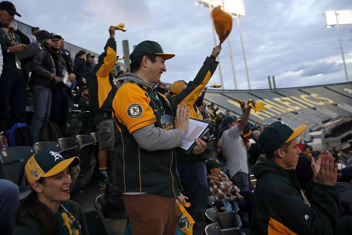 Oakland A's fan Jeremy Koo celebrates Ben Zobrist's 2-run home run in 1st inning against Texas Rangers in season opener at O.co Coliseum in Oakland, Calif., on Monday, April 6, 2015.