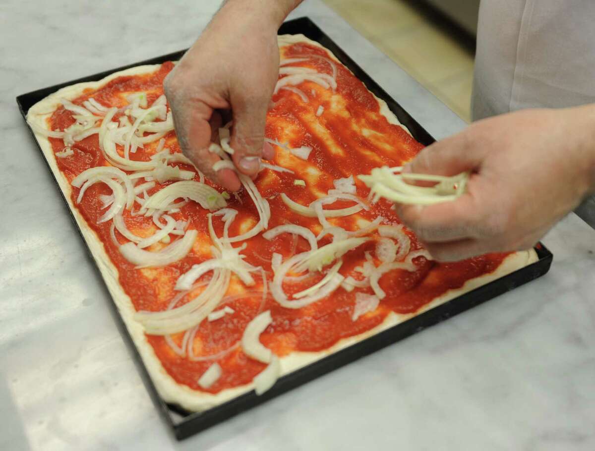 Owner Nunzio DeTommaso makes a pizza at Gravina Pizzeria in the Cos Cob section of Greenwich, Conn. Tuesday, April 7, 2015. The pizzeria makes crsipy, light Roman-style pies available by the slice and weighed by the pound.