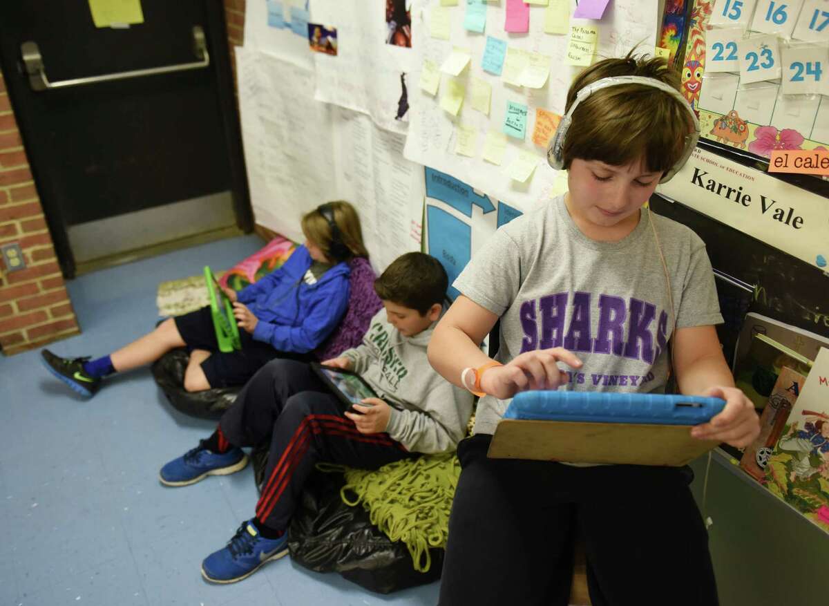 Fifth grader Robert Rota, right, uses the eSpark iPad app beside classmates Arto Stepanian, left, and Louis Ceci at Parkway School in Greenwich, Conn. Thursday, March 26, 2015. Parkway is the only school in the Greenwich district to use eSpark, a personalized iPad app for students that curates a variety of education applications for students to use supplemental to standard lessons. Through apps, videos and assessments, eSpark gives students personalized learning programs and lets teachers give students more customized feedback.