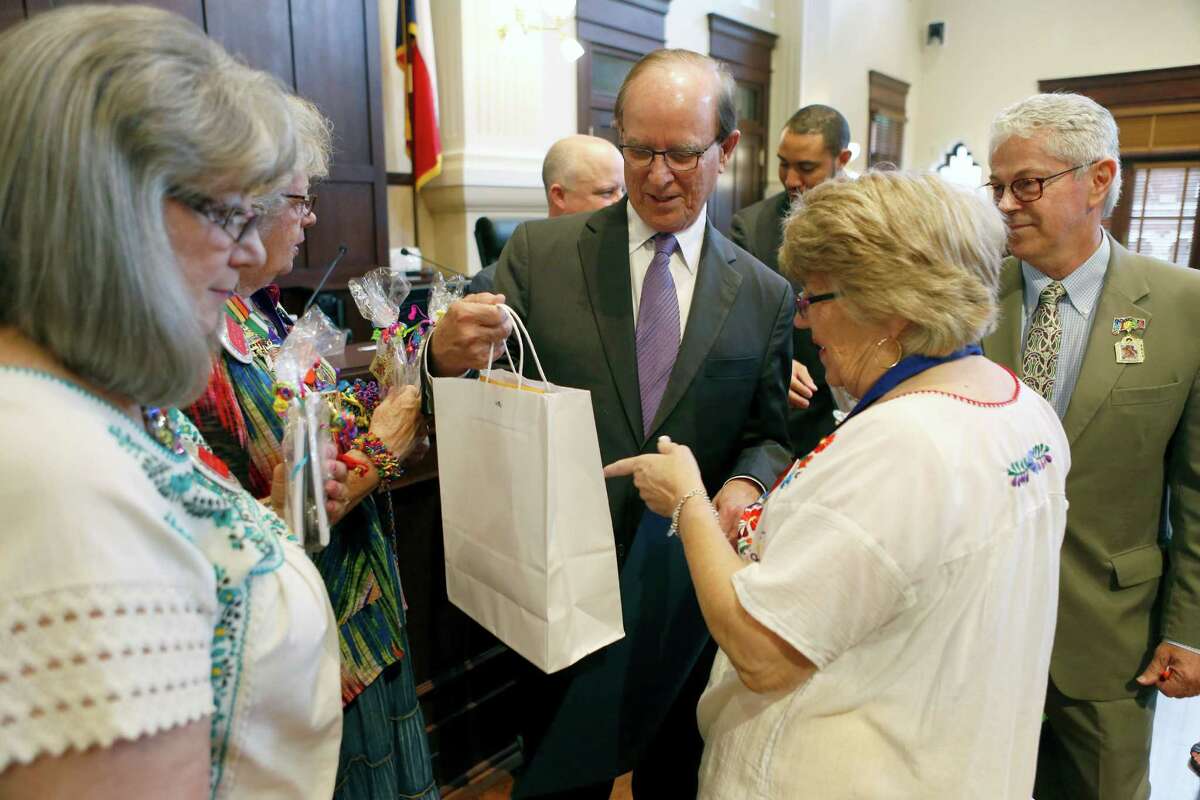 County Judge Nelson Wolff receives a small gift bag April 7 from members of the San Anotnio Conservation Society during the ceremonial portion of the Bexar County Commissioners Court. The commissioners read several Fiesta-related proclamations including one recognizing the conservation society for its work developing A Night in Old San Antonio.