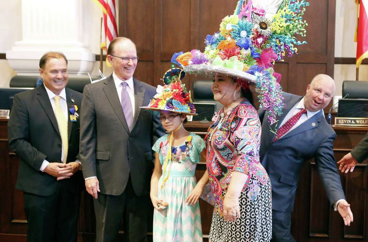 Bexar County commissioner Kevin Wolff, right, jokingly tries to be seen Tuesday morning April 7, 2015 from behind Minu Martinez's Fiesta hat during the ceremonial portion of the commissioners court meeting. Also pictured are commissioners Chico Rodriguez, left, county judge Nelson Wolff, and Anahi Gutierrez, 9. The commissioners read several Fiesta-related proclamations before the start of their regular meeting.
