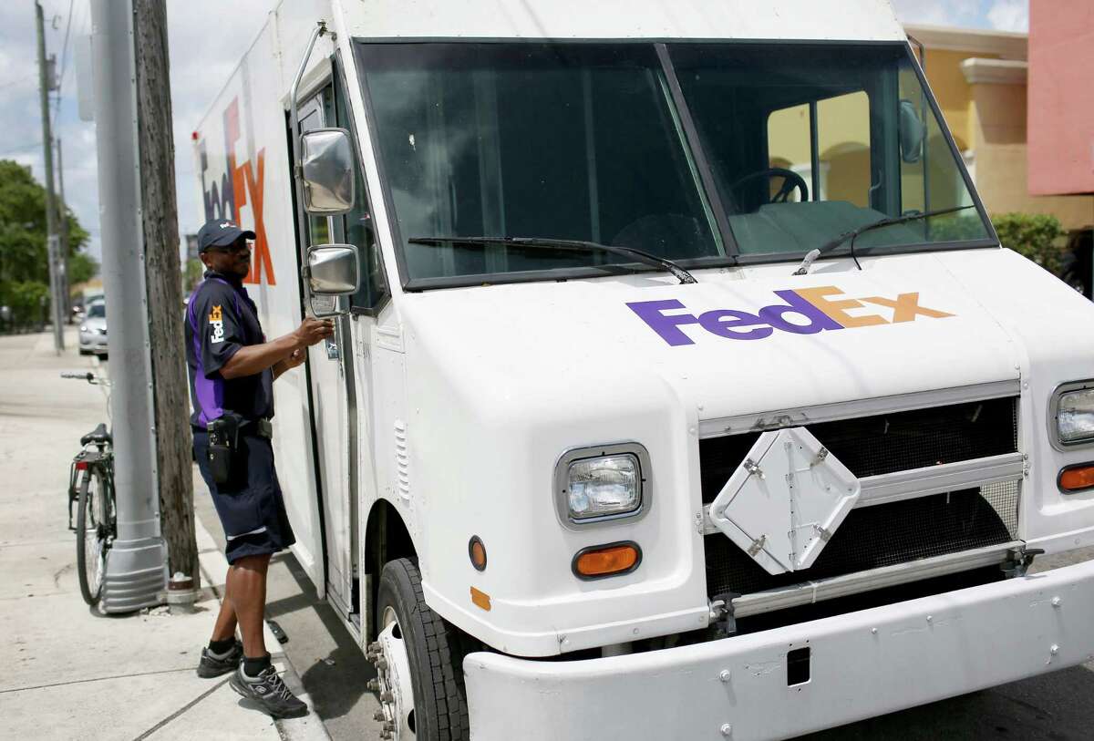 MIAMI, FL - APRIL 07: FedEx delivery person, Chris Aniemeka, delivers packages as the company announced they plan to purchase TNT Express NV on April 7, 2015 in Miami, Florida. FedEx Corp. announced today that it would buy the Dutch parcel-delivery firm for about $4.8 billion as it expands in the European market. (Photo by Joe Raedle/Getty Images)