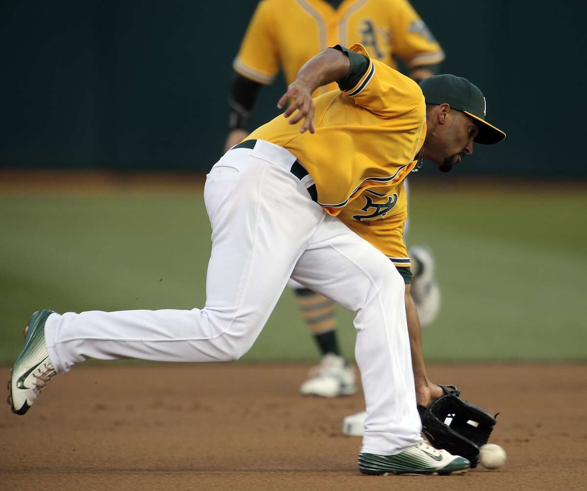 Marcus Semien (10) fields a ball in the first inning as the Oakland Athletics played the Texas Rangers at O.Co Coliseum on Tuesday, April 7, 2015, in Oakland, Calif.