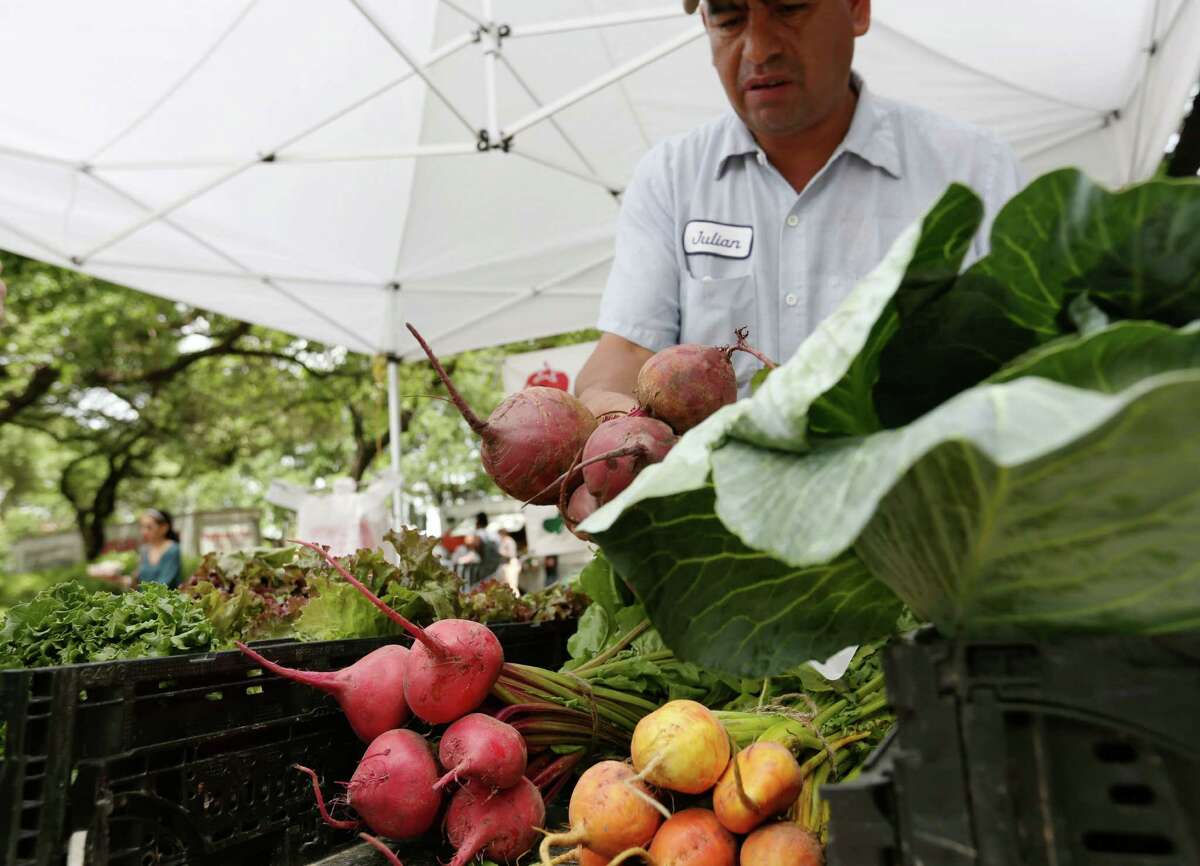 Justo Mories waits for customers at the weekly farmer's market in Hermann Square Wednesday, April 8, 2015, in Houston.